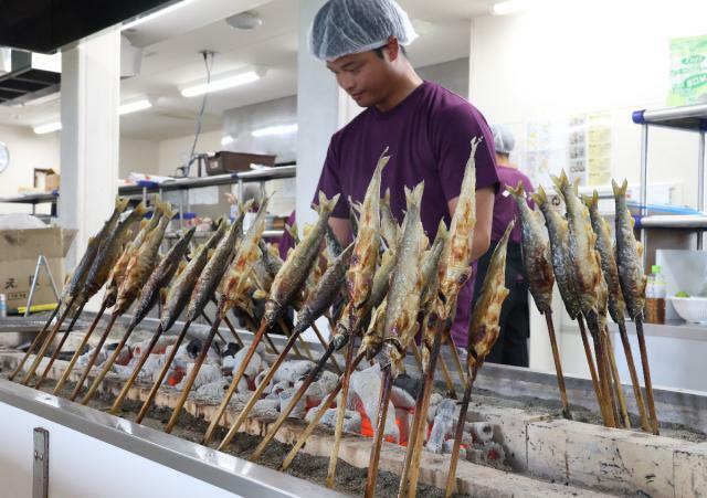 炭火でじっくり焼き上げられる食事処のアユの塩焼き＝２８日午前、延岡市大貫町の「かわまち交流館」