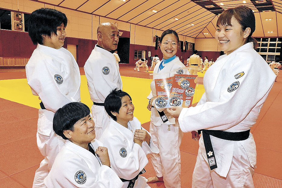 ワッペンをアピールする小坂さん（右）と柔道仲間＝小松市武道館