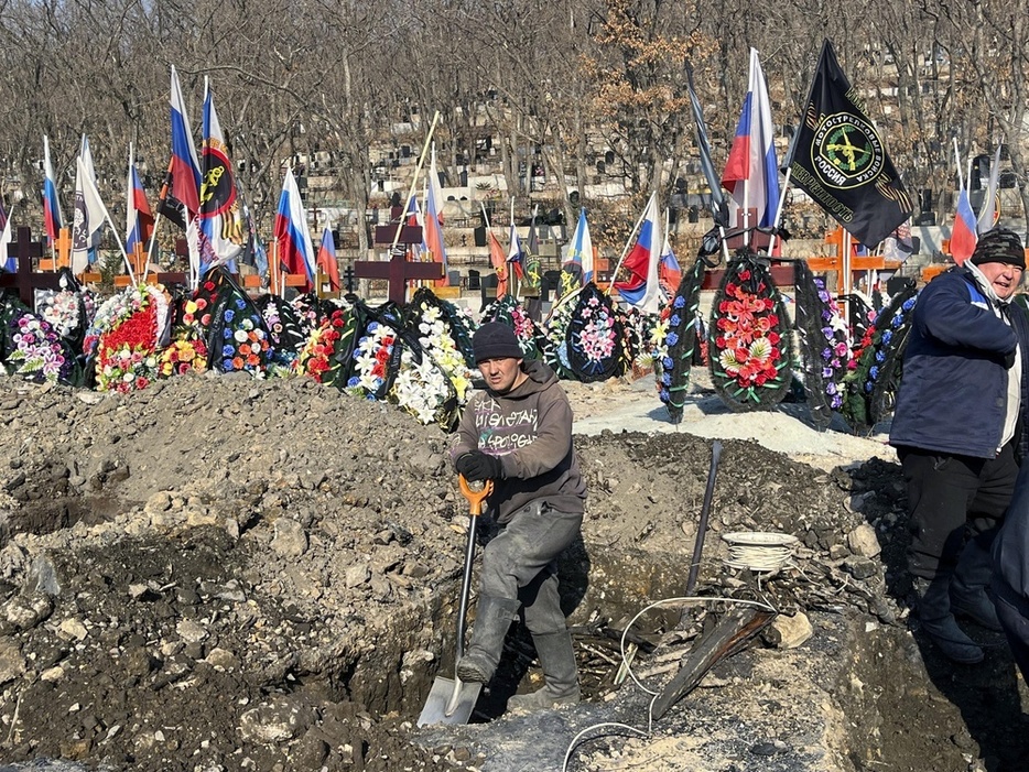 ロシア極東ウラジオストクにあるウクライナ侵攻作戦の戦死者らの墓で、墓穴を掘る男性＝1月