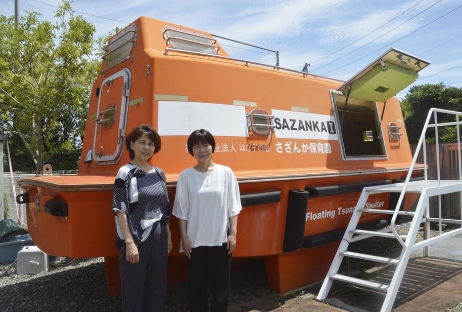 津波に備えた救命艇型シェルターの前に立つ「さざんかこども園」運営法人理事長の安藤香澄さん（左）＝2024年7月、浜松市