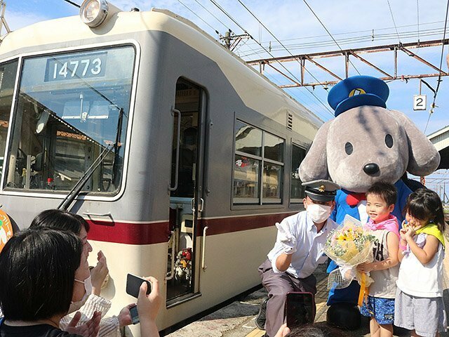 ホームで運転士に花束を贈る園児とくろワン＝富山地方鉄道電鉄黒部駅