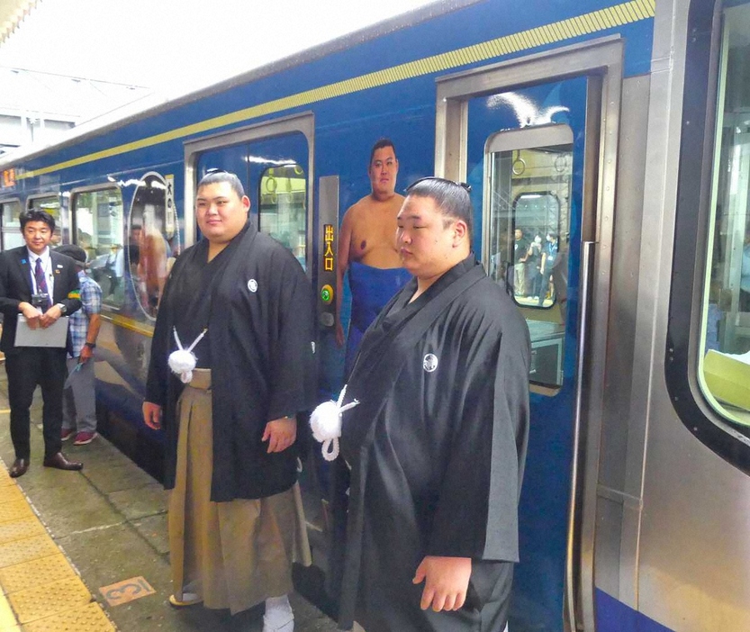 えちごトキめき鉄道のラッピング車両の前で記念写真に収まる大の里（中央）と欧勝海（撮影・前川　晋作）