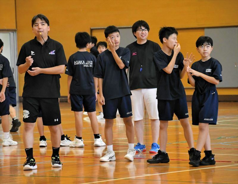 中学生に指導する久冨さん（左）。右から３人目が堀越さん