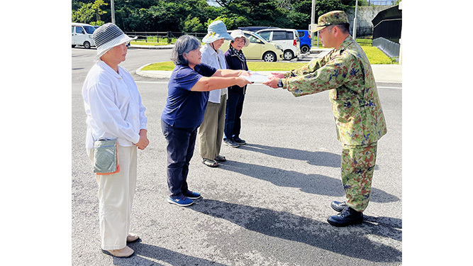 石垣駐屯地への要請書を手渡す連絡会メンバー（写真左）＝20日午前、石垣駐屯地