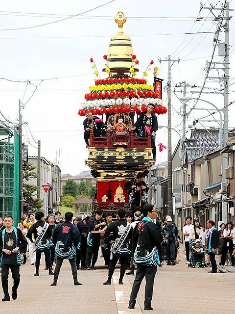 住民たちに見守られて巡行する古新町の曳山＝射水市港町