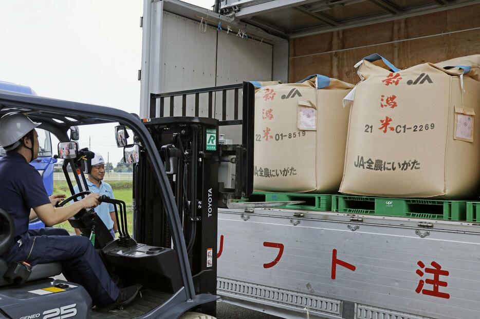 全国農業協同組合連合会新潟県本部のコシヒカリ県外向け出荷式で、トラックに積み込まれる県産米＝12日午前、新潟市