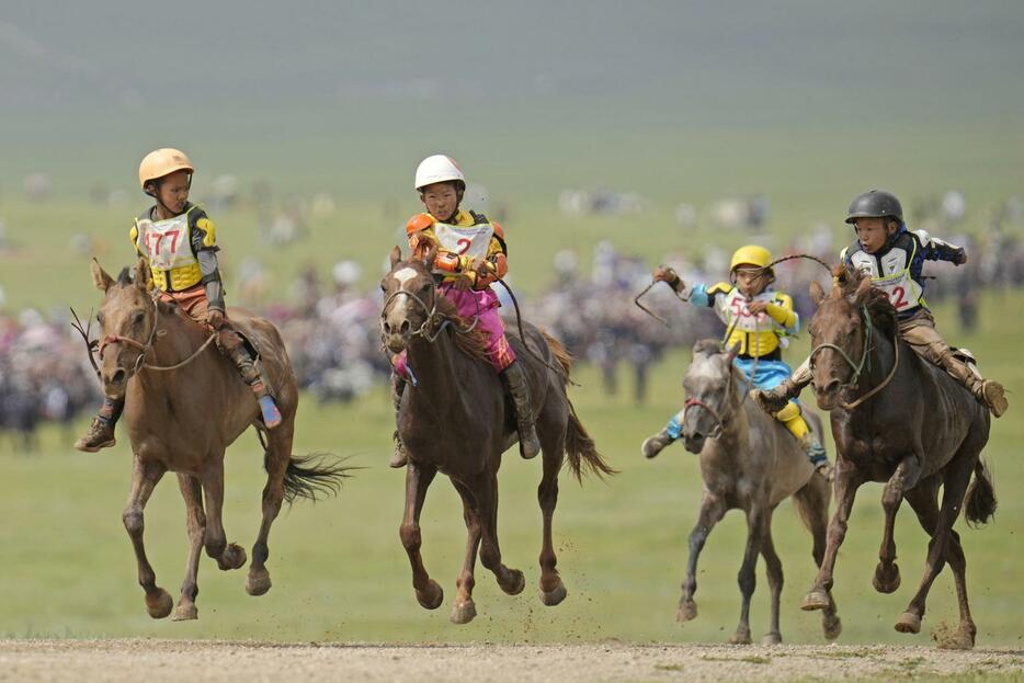 モンゴル最大のスポーツの祭典「ナーダム」の馬レースで、草原を駆ける馬。騎手の多くは小学生だ＝2024年7月、ウランバートル郊外（共同）