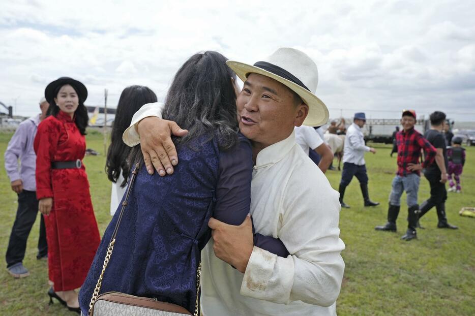 「ナーダム」のレースで自身が調教した馬が入賞し、関係者と喜ぶタミルさん（右）＝2024年7月、ウランバートル郊外（共同）