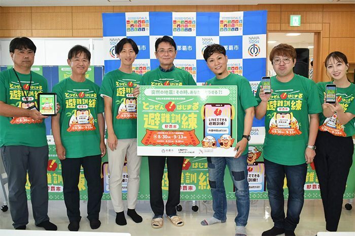 LINEを使った避難訓練をPRする南方本部長（左から3人目）と知念市長（同4人目）＝30日、那覇市松山の津波避難ビル