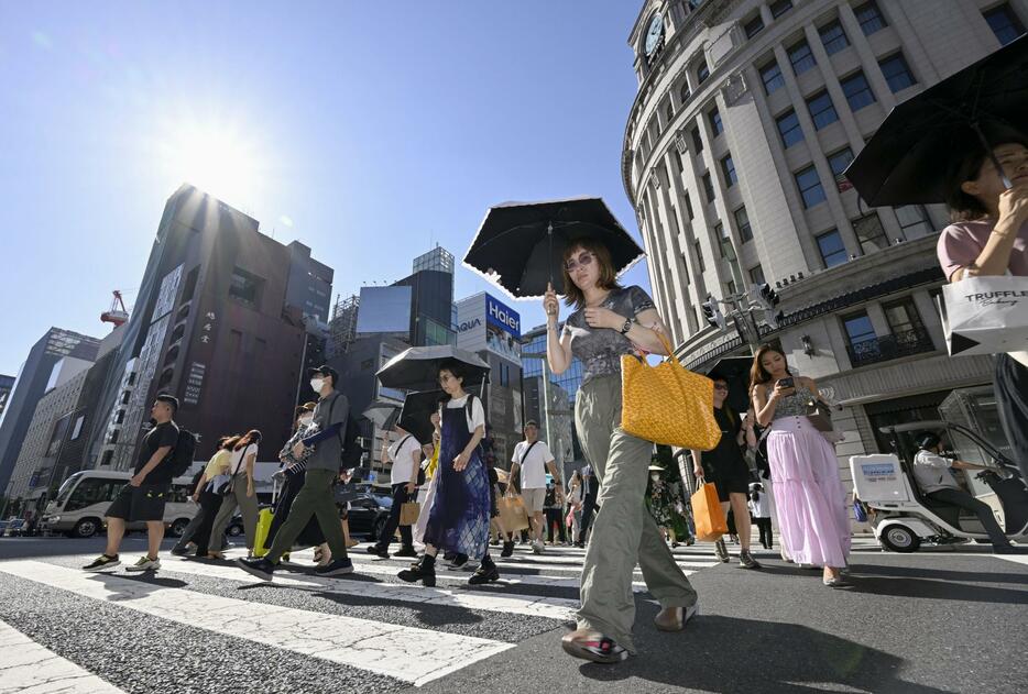 強い日差しの中、東京・銀座で日傘を差して歩く人たち＝20日午後