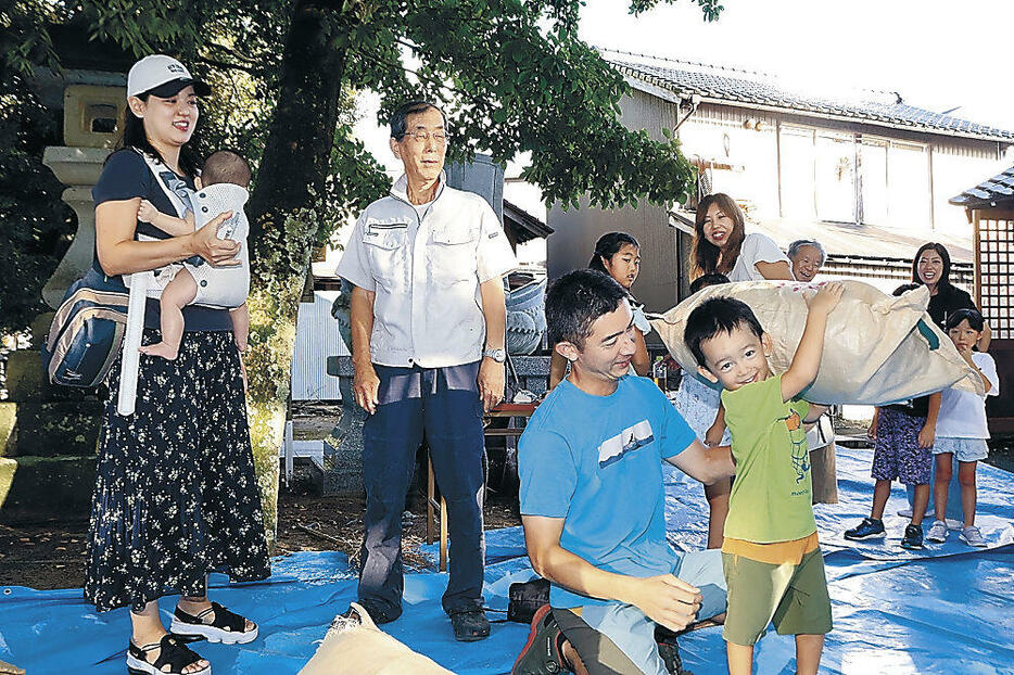 盤持ち大会で袋を担ぎ上げる子ども=小松市向本折町