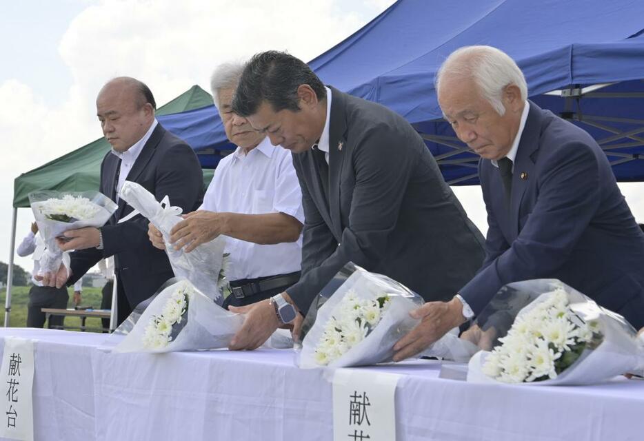 鬼怒川堤防の決壊現場で献花する神達岳志常総市長(右から2人目)ら=常総市三坂町