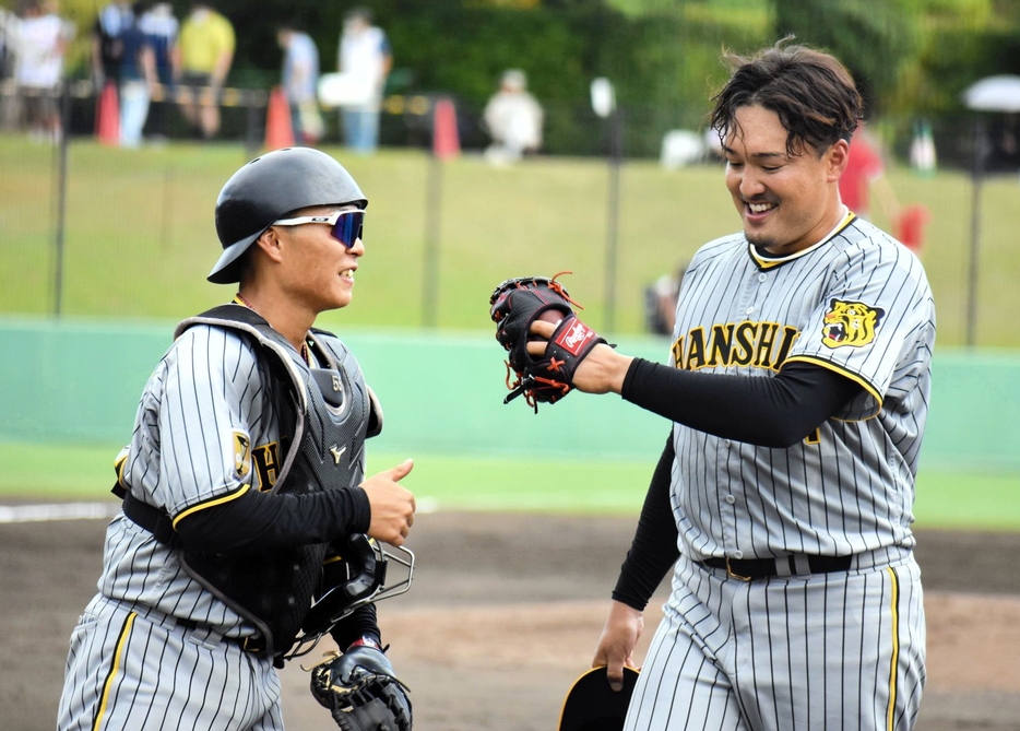 　３回無失点に抑え藤田とグータッチを交わす秋山（右）