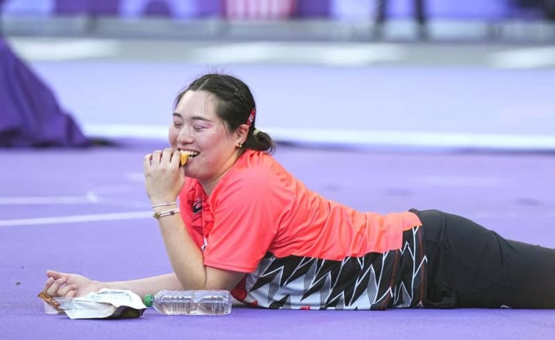 競技の合間にカステラを食べる北口榛花選手＝８月１０日、パリ郊外（共同）