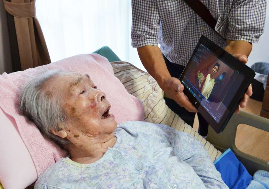 袴田ひで子さんからのビデオメッセージを見る原口アヤ子さん＝２９日、鹿児島県内の介護施設