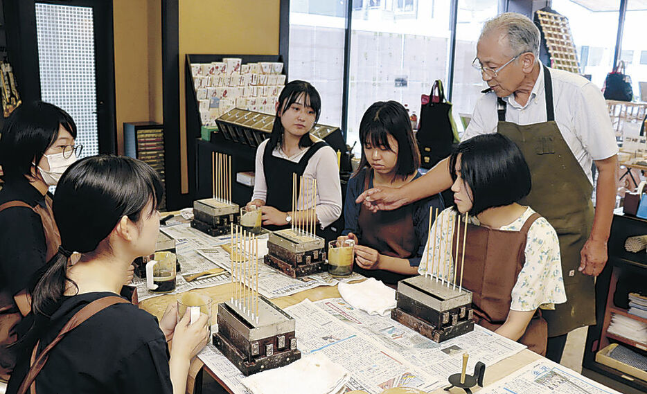 高澤さんの指導で和ろうそく作りを体験するボランティア＝七尾市一本杉町