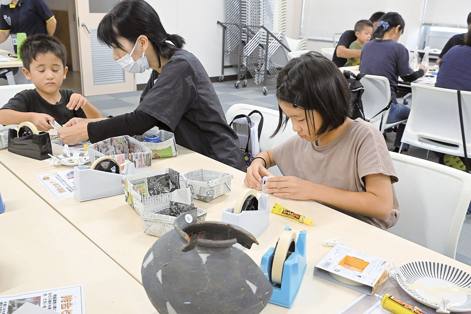 割れた陶器を修復する「接合」作業に挑戦する参加者＝28日、鹿児島県伊仙町