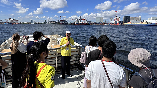 クルーズ船で東洋建設スタッフの説明を聞く参加者ら