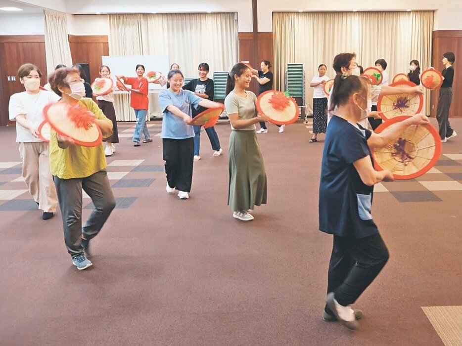 花がさを手に踊りを練習する参加者