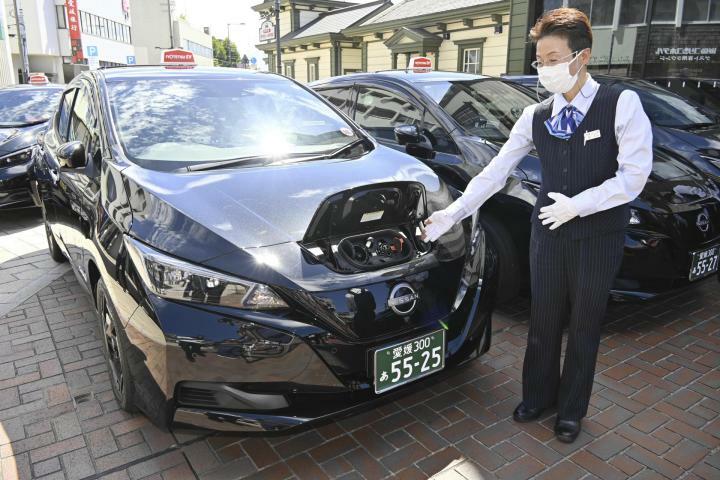 伊予鉄タクシーが導入したEV車両。前部に充電ケーブルを接続する＝11日午後、松山市道後町1丁目