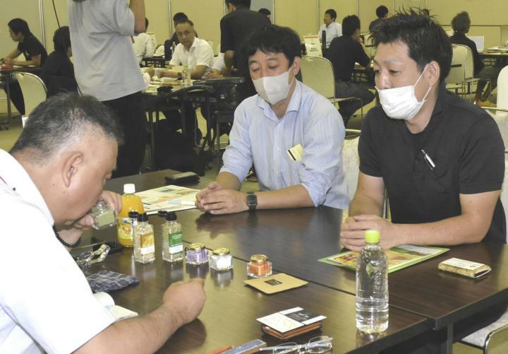 バイヤー（左）に商品を売り込む事業者＝13日午前、松山市湊町7丁目