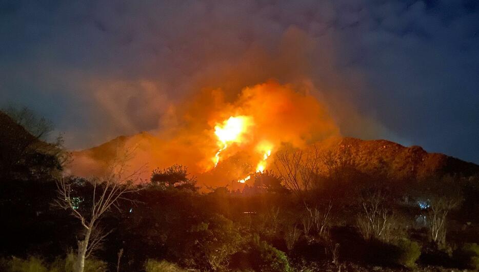 炎を上げて燃える山林（18日午後7時46分撮影）