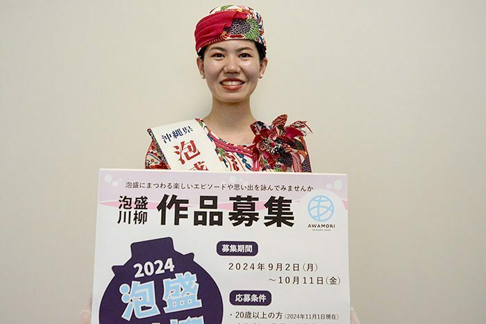 泡盛川柳の応募を呼び掛ける2024年泡盛の女王の仲宗根夏希さん＝2日、那覇市泉崎の琉球新報社