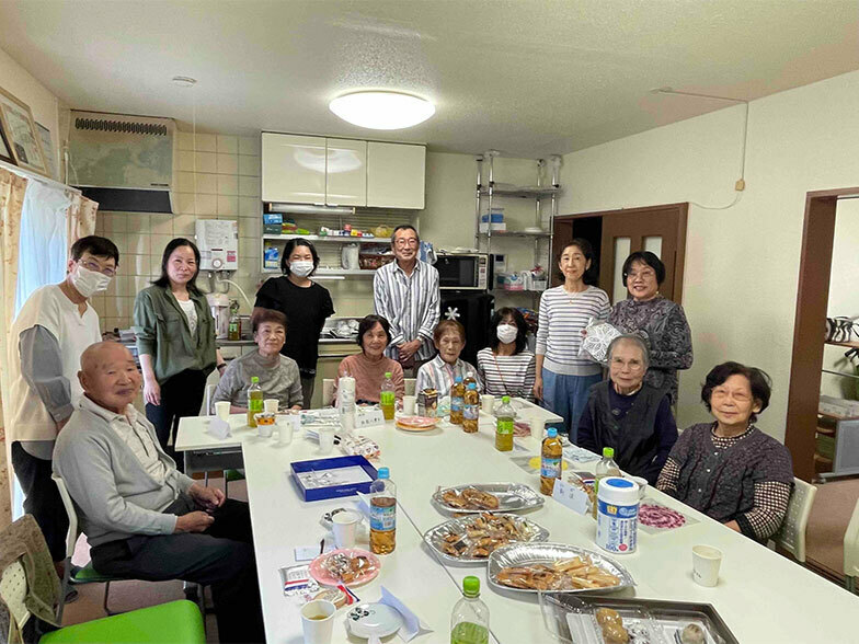 「みんなの部屋」で飲み物やお菓子などを用意しておしゃべりする「ふれあいサロン」実施時の記念撮影（画像提供／竹山16-2団地管理組合法人）