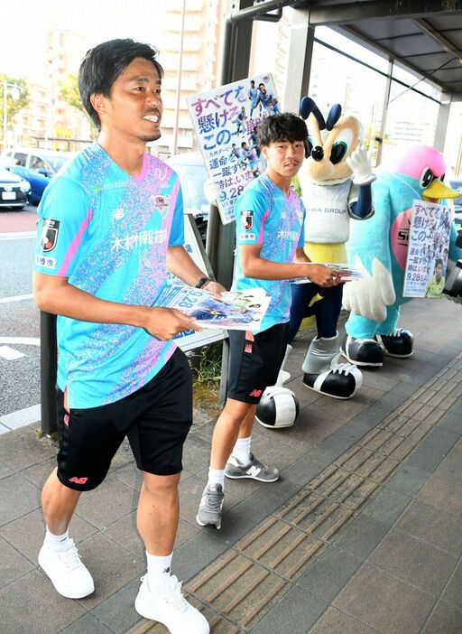 JR鳥栖駅前でJ1福岡のマスコット「アビーくん」（左から3人目）とともに九州ダービーをPRする、J1鳥栖の丸橋（左端）ら