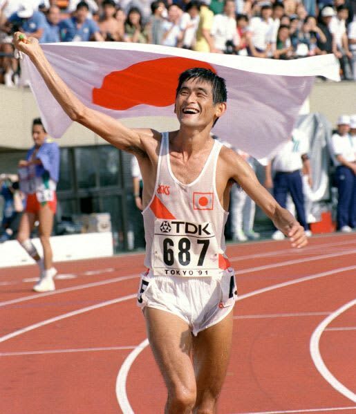 １９９１年９月、陸上世界選手権の男子マラソンで日本に初の金メダルをもたらし、日の丸の旗を掲げて観客の声援にこたえる谷口浩美さん＝国立競技場