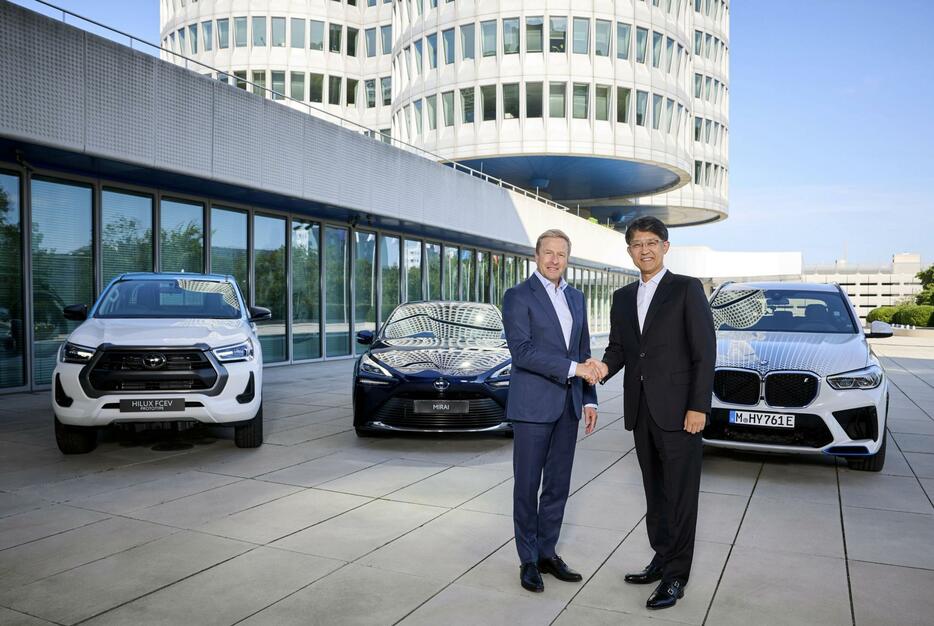 BMWのオリバー・ツィプセ会長（左）と握手するトヨタ自動車の佐藤恒治社長＝ドイツ・ミュンヘン（共同）