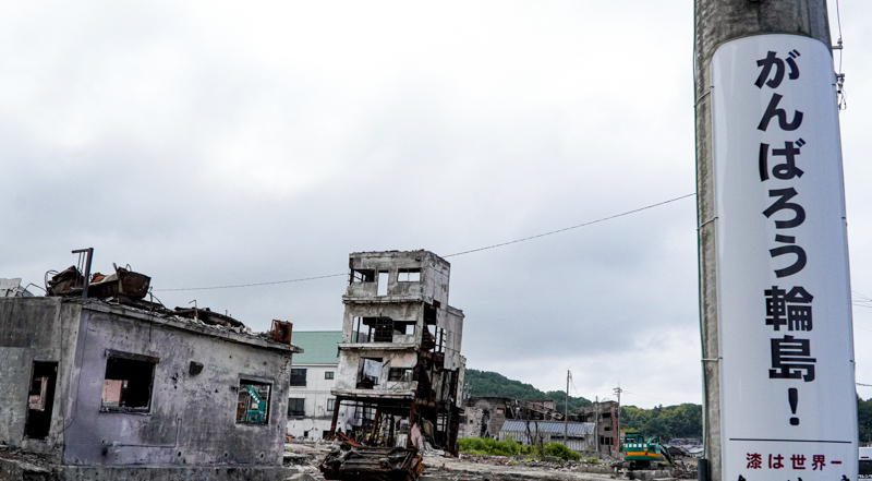 地震による火災で焼失した輪島の中心街。「がんばろう」の看板下にも「漆」の文字がある