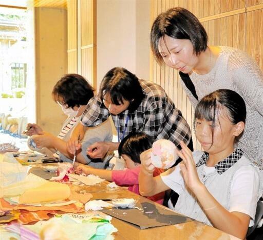 越前和紙を使ったあかり作りに挑戦する子どもら=9月23日、福井県福井市の県立一乗谷朝倉氏遺跡博物館