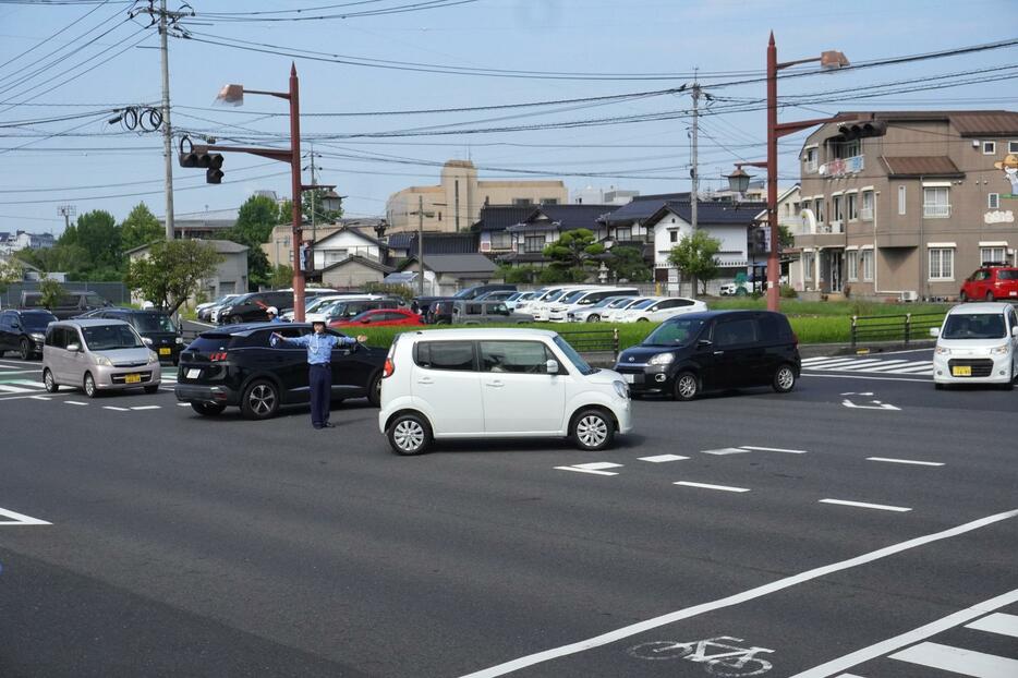 手信号で車を誘導する津山署員=岡山県津山市で