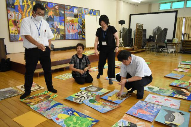 子どもたちの作品を吟味する審査員＝２４日午後、宮崎市フェニックス自然動物園