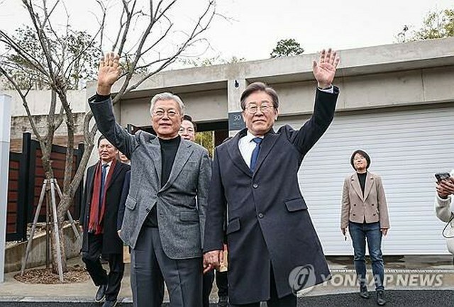 2月24日、文前大統領（左）の自宅を訪れた共に民主党の李代表（同党提供）＝（聯合ニュース）≪転載・転用禁止≫