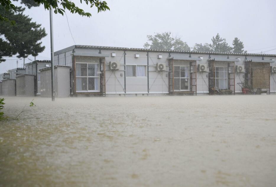 激しい雨が降る石川県珠洲市の仮設住宅団地。近くを流れる川が氾濫し、住宅が立つ小学校のグラウンドは冠水。一時床上浸水した棟もあり、住民は「こんなふうになると思わなかった」と話した＝22日午前8時40分