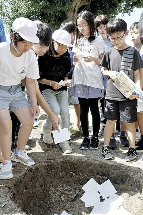 植樹で掘った穴に手紙を“投かん”する児童たち