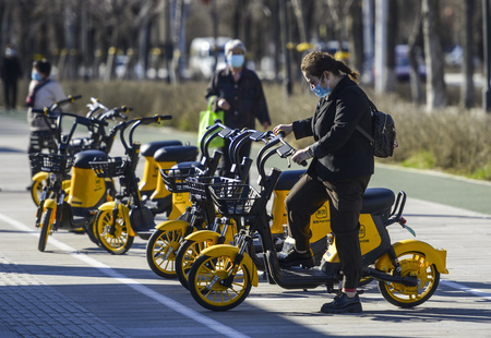 新疆ウイグル自治区ウルムチ市でシェア電動自転車を指定された位置に停める女性（2021年4月12日撮影、資料写真）。