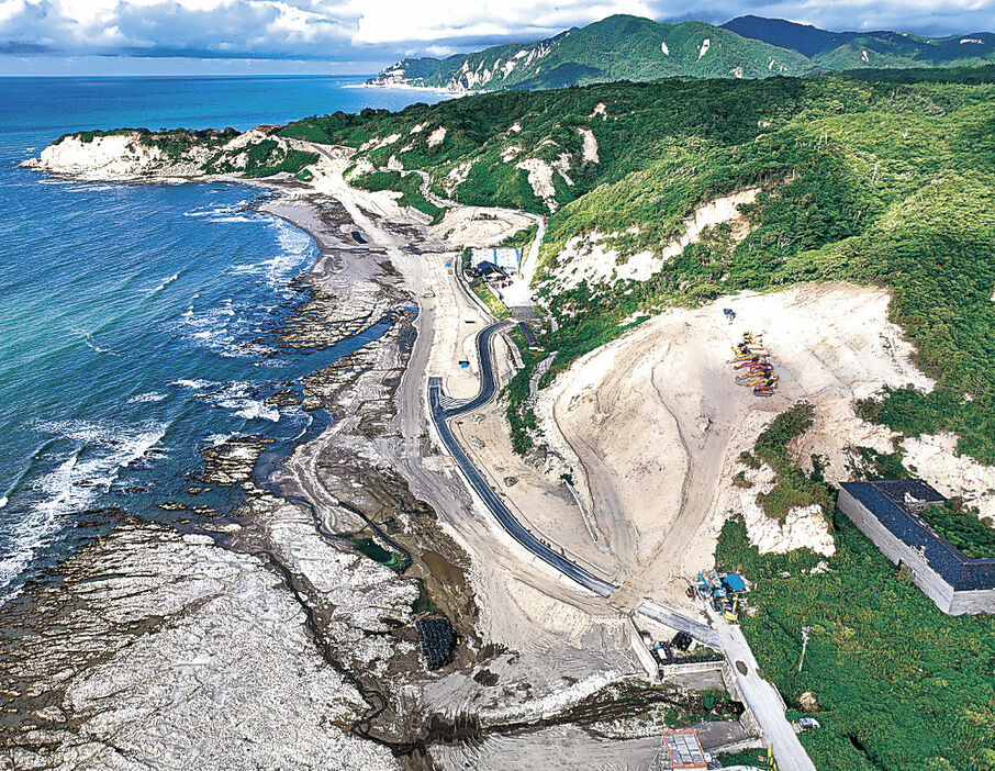 重機を無人化して復旧工事が進められる国道２４９号大川浜工区＝８月、輪島市内（ドローンから）