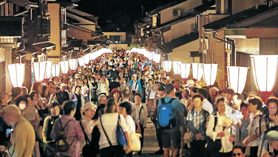 ぼんぼりに照らされた幻想的な町を散策する大勢の観光客＝２日、諏訪町