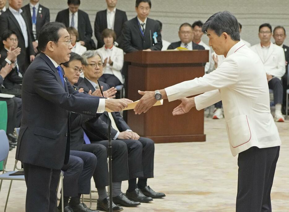 パリ五輪・パラリンピック日本選手団と面会し、五輪選手団の尾県貢団長（右）に感謝状を授与する岸田首相＝11日午前、首相官邸