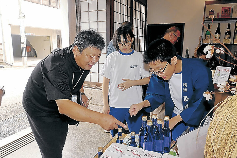 コラボ商品を販売する生徒＝富山市八尾町東町の玉旭酒造