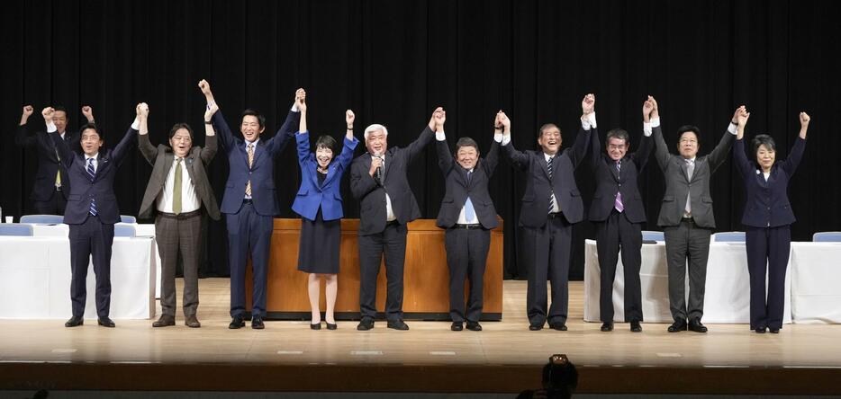 自民党総裁選の演説会を終え手を取り合う（左から）小泉元環境相、林官房長官、小林前経済安保相、高市経済安保相、（1人おいて）茂木幹事長、石破元幹事長、河野デジタル相、加藤元官房長官、上川外相＝18日午後、松山市