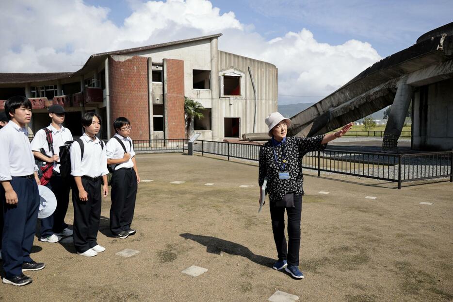 震災遺構・大川小を視察する輪島高の生徒らと案内する三條すみゑさん（右端）＝27日午前、宮城県石巻市