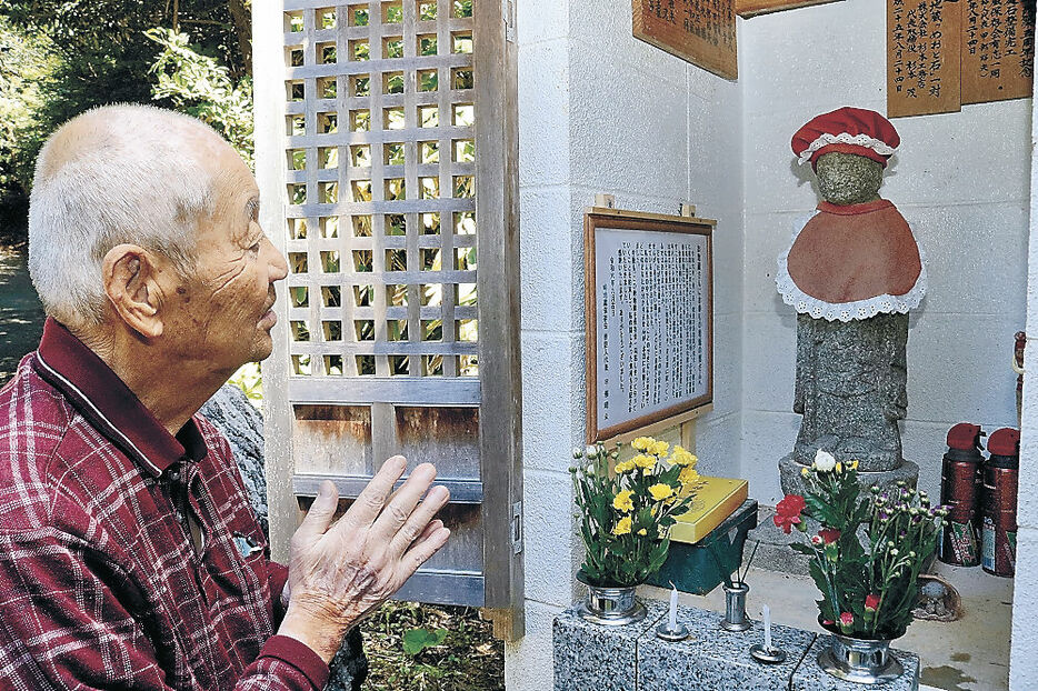 元通りになった峠地蔵に手を合わせる甲部さん＝中能登町能登部上