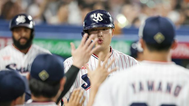 ベンチで祝福されるヤクルト村上宗隆選手(写真：時事)