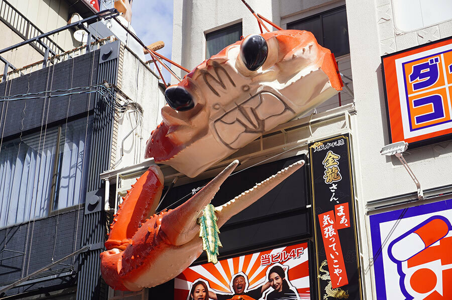 「金龍ラーメン」の立体看板・龍のしっぽを挟んだカニ（9月17日撮影・大阪市内）