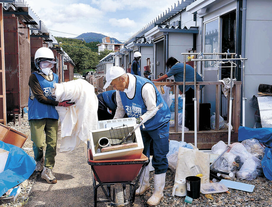 仮設住宅から災害廃棄物を運び出すボランティア＝２４日午後０時２０分、輪島市宅田町