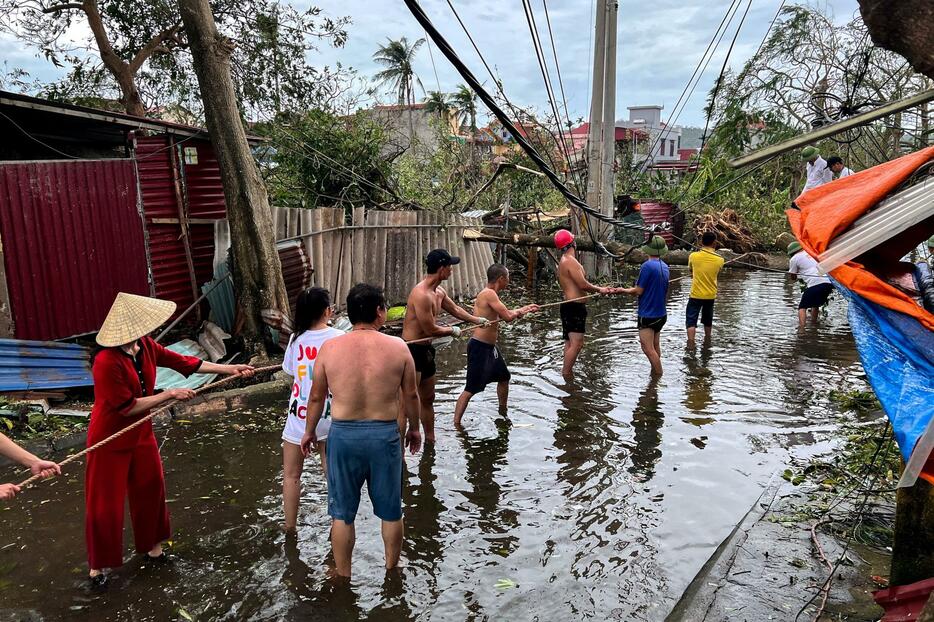 8日、ベトナム北部ハイフォン市で、台風により倒れた樹木を取り除く人々（ロイター＝共同）